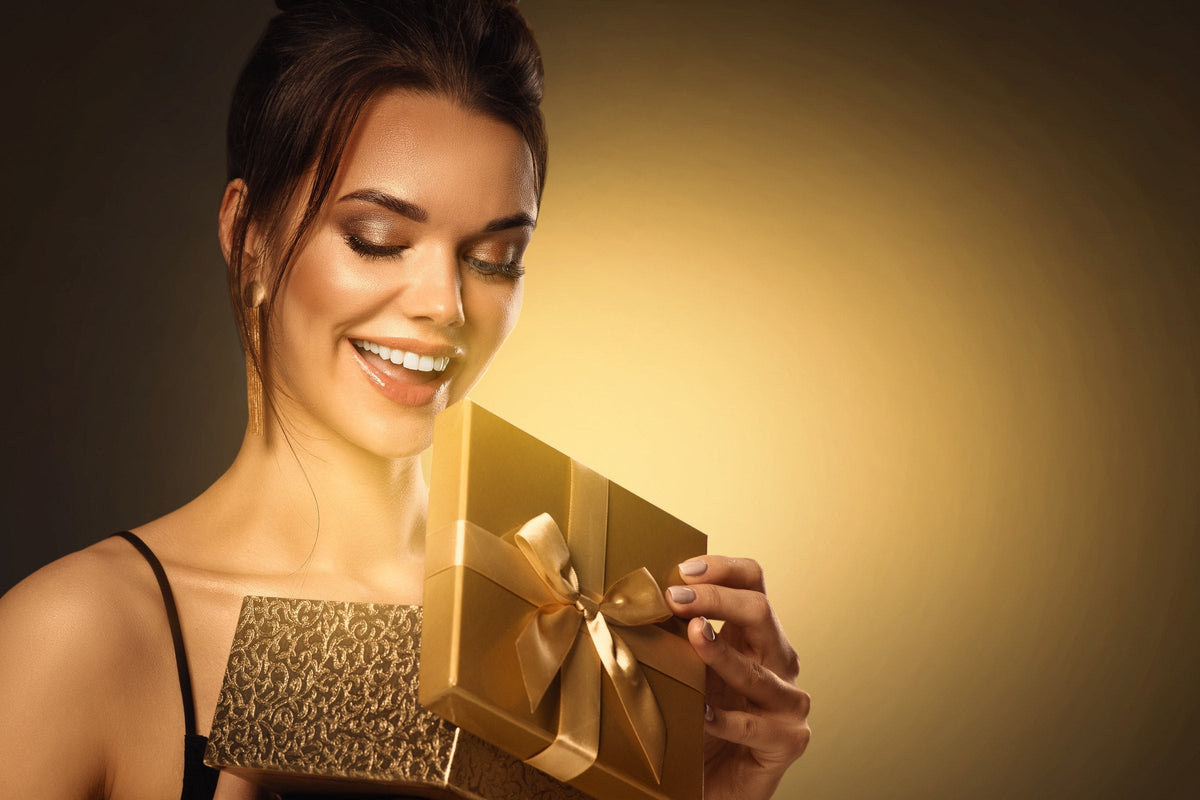 A smiling woman opening a gift box