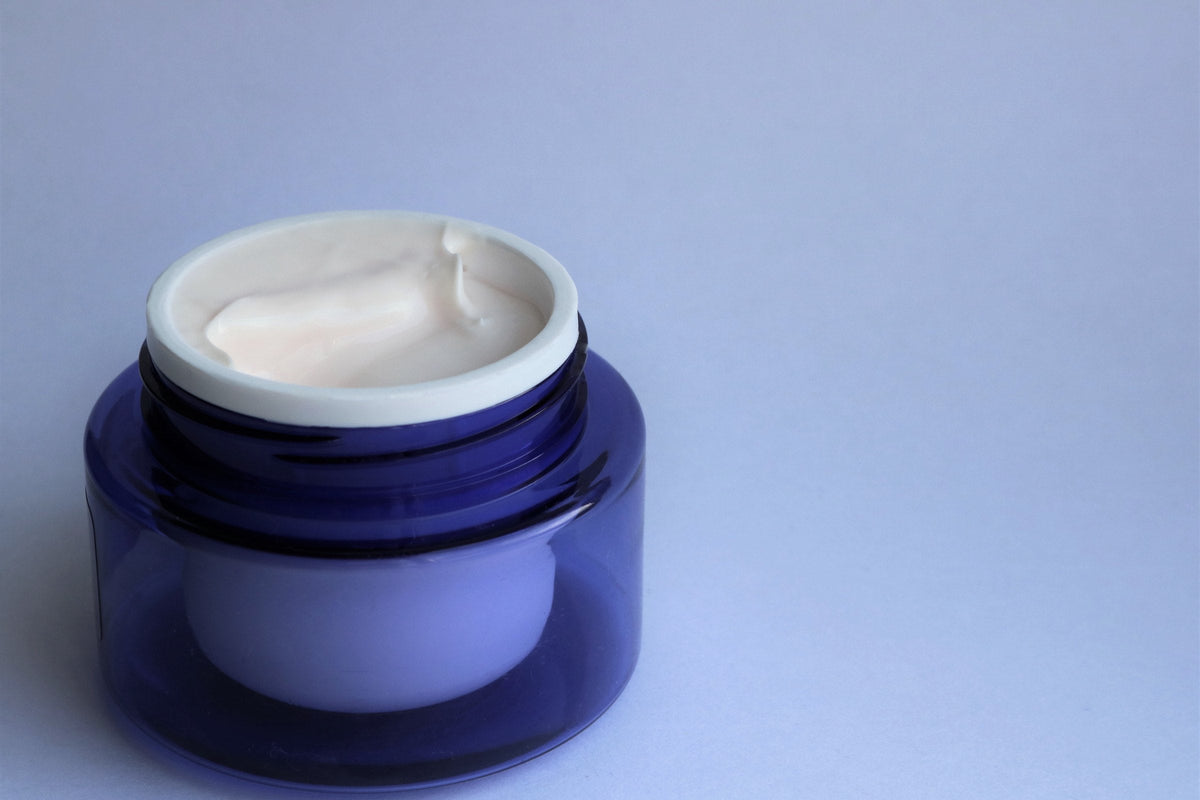Two jars of face cream, one light and one dark, for day and night