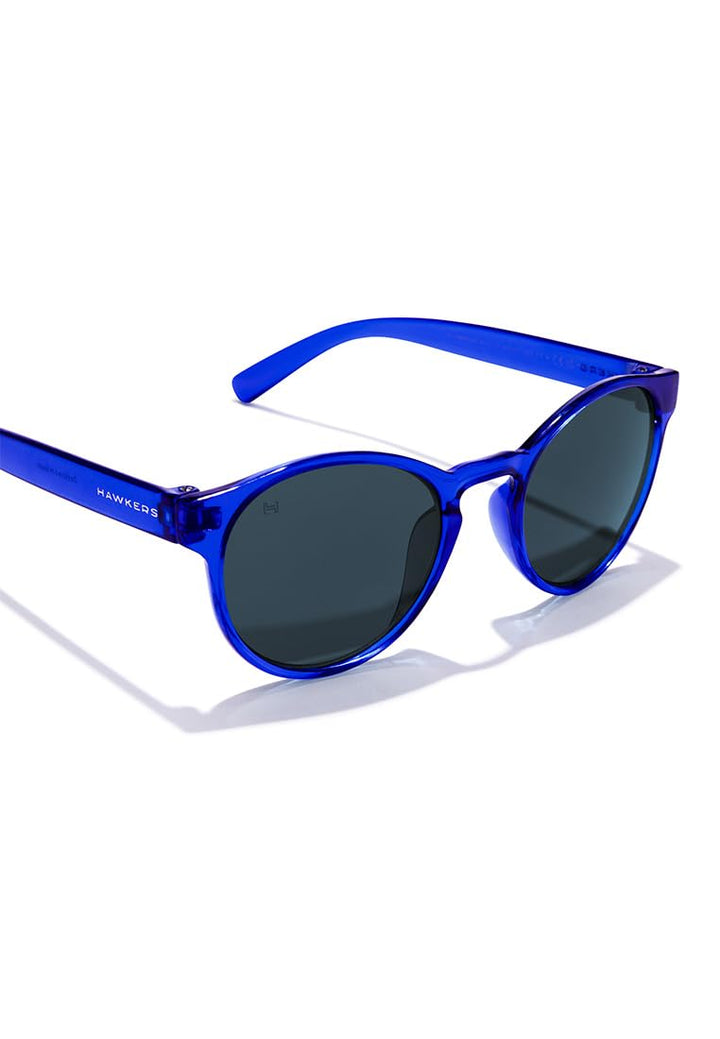 Hawkers round kids sunglasses, transparent blue plastic frame, keyhole bridge, dark round lenses