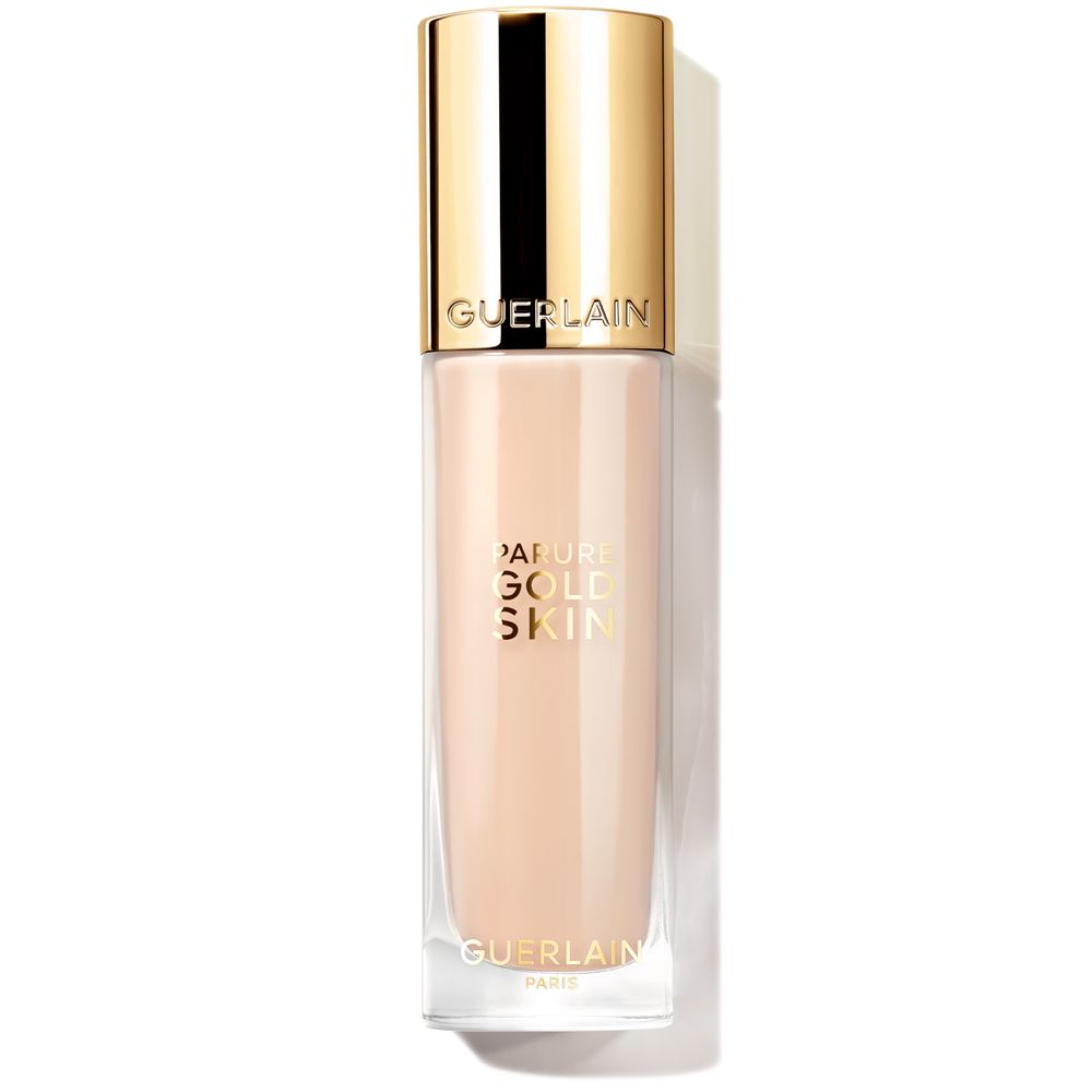 Guerlain Rectangular glass liquid foundation bottle with gold metallic cap, gold embossed text, transparent beige liquid