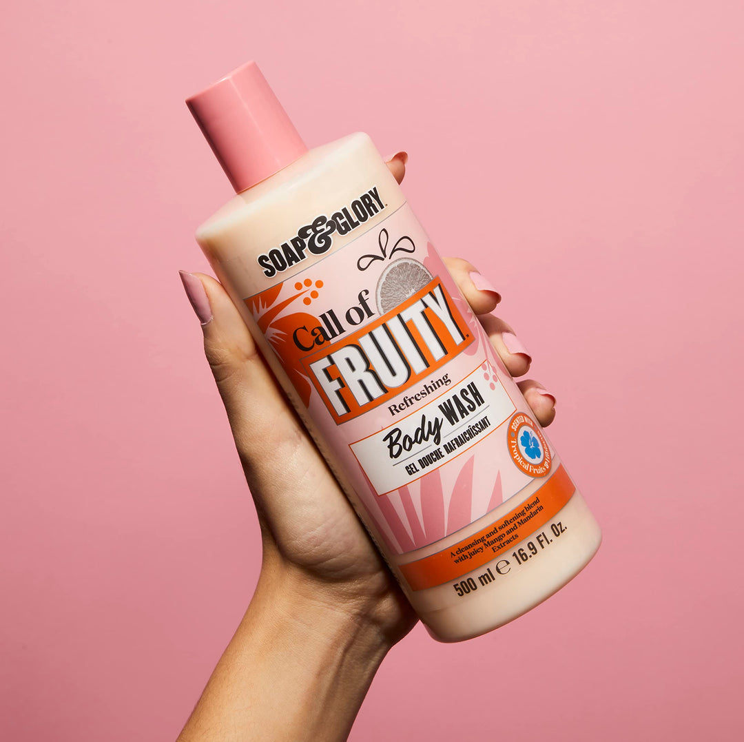 Soap &amp; Glory Plastic cylindrical body wash bottle in pink, orange and beige with flip-top cap, fruit and floral graphics, bold text branding, measurement markings — .