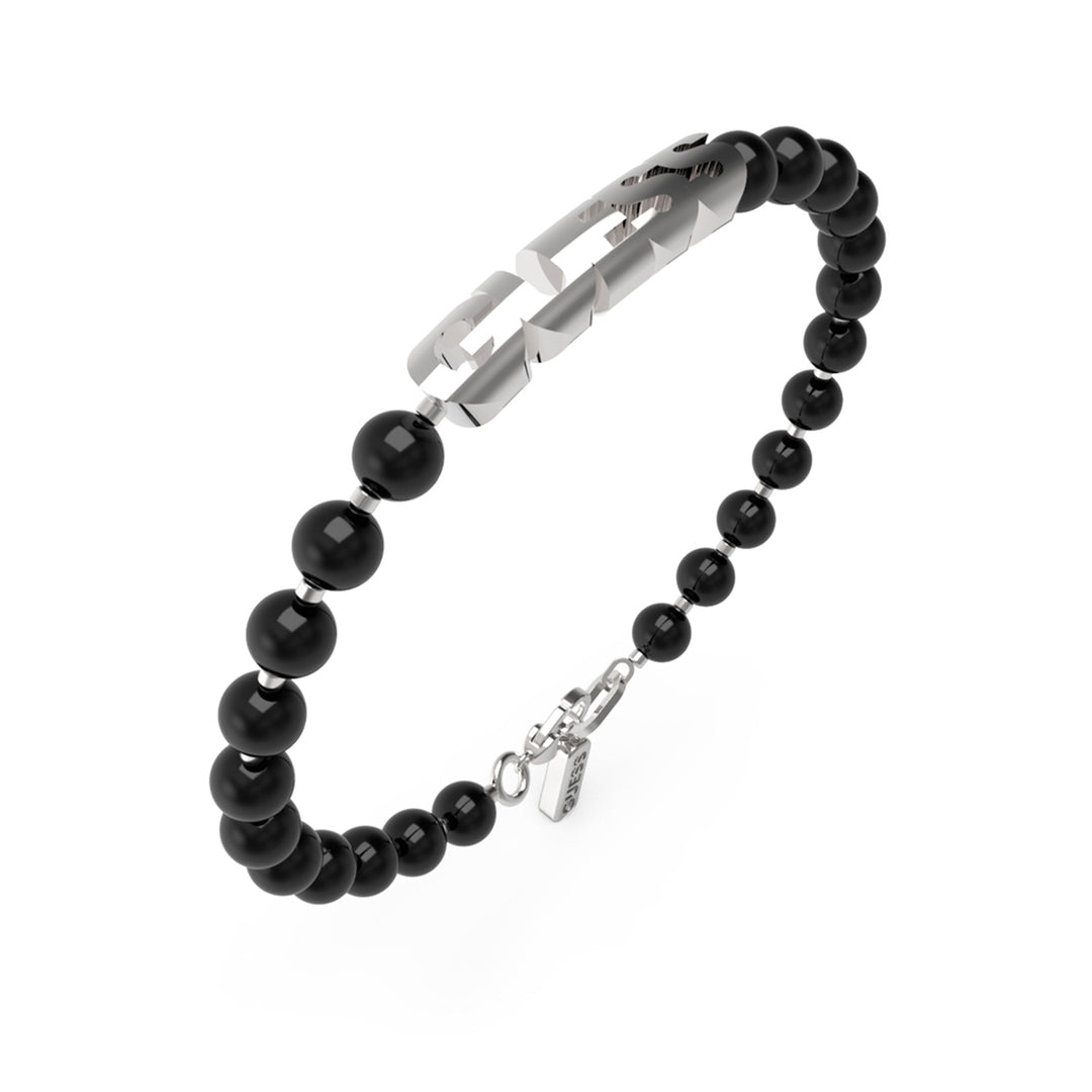 Black beaded bracelet with silver cut-out metal plate and metallic clasp on neutral background