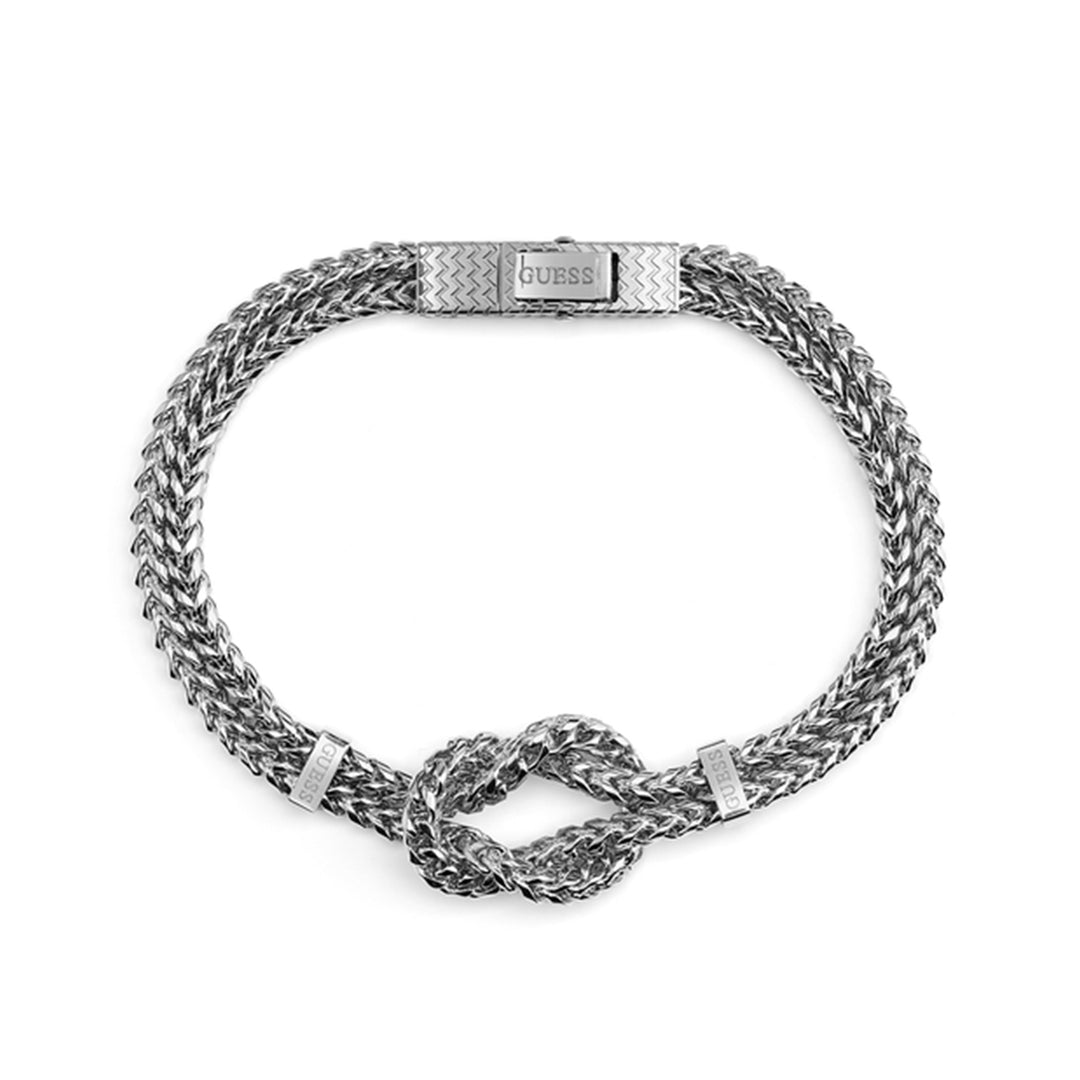 Silver braided metal bracelet with knot detail and patterned clasp on a neutral background